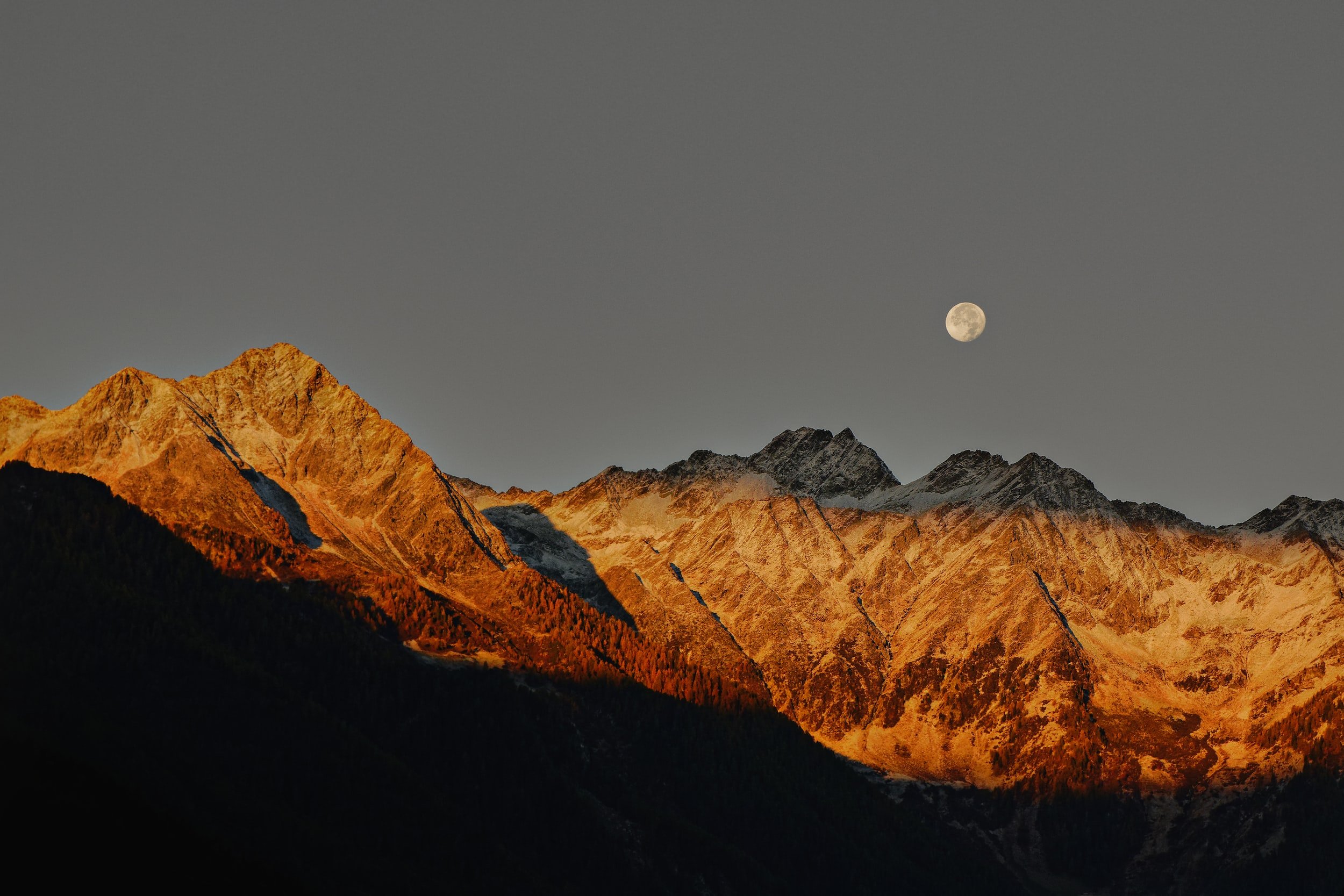 Mountains at golden hour under a full moon